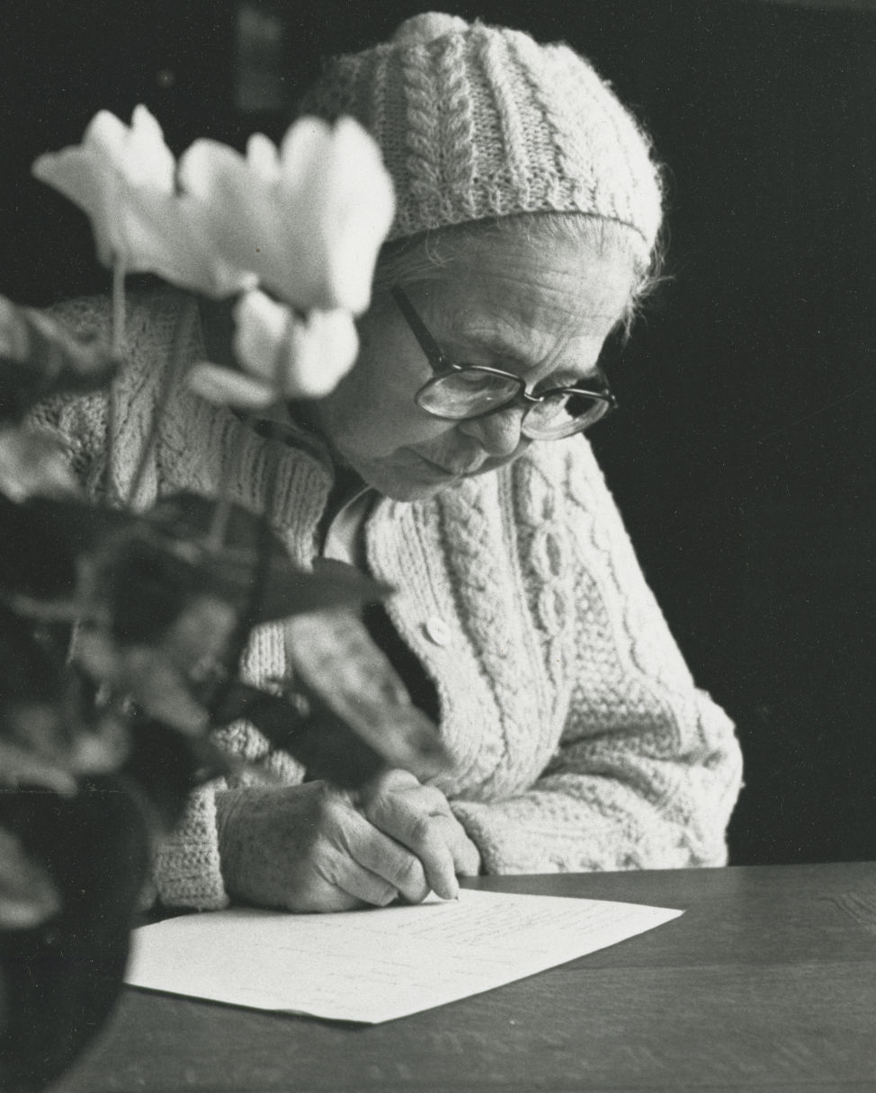 Close-up photo of Ade Bethune writing, undated black and white photo